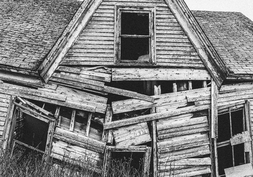 Black and white image of a dilapidated barn.